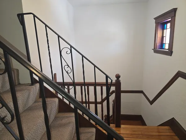 a view of staircase with wooden floor and white walls