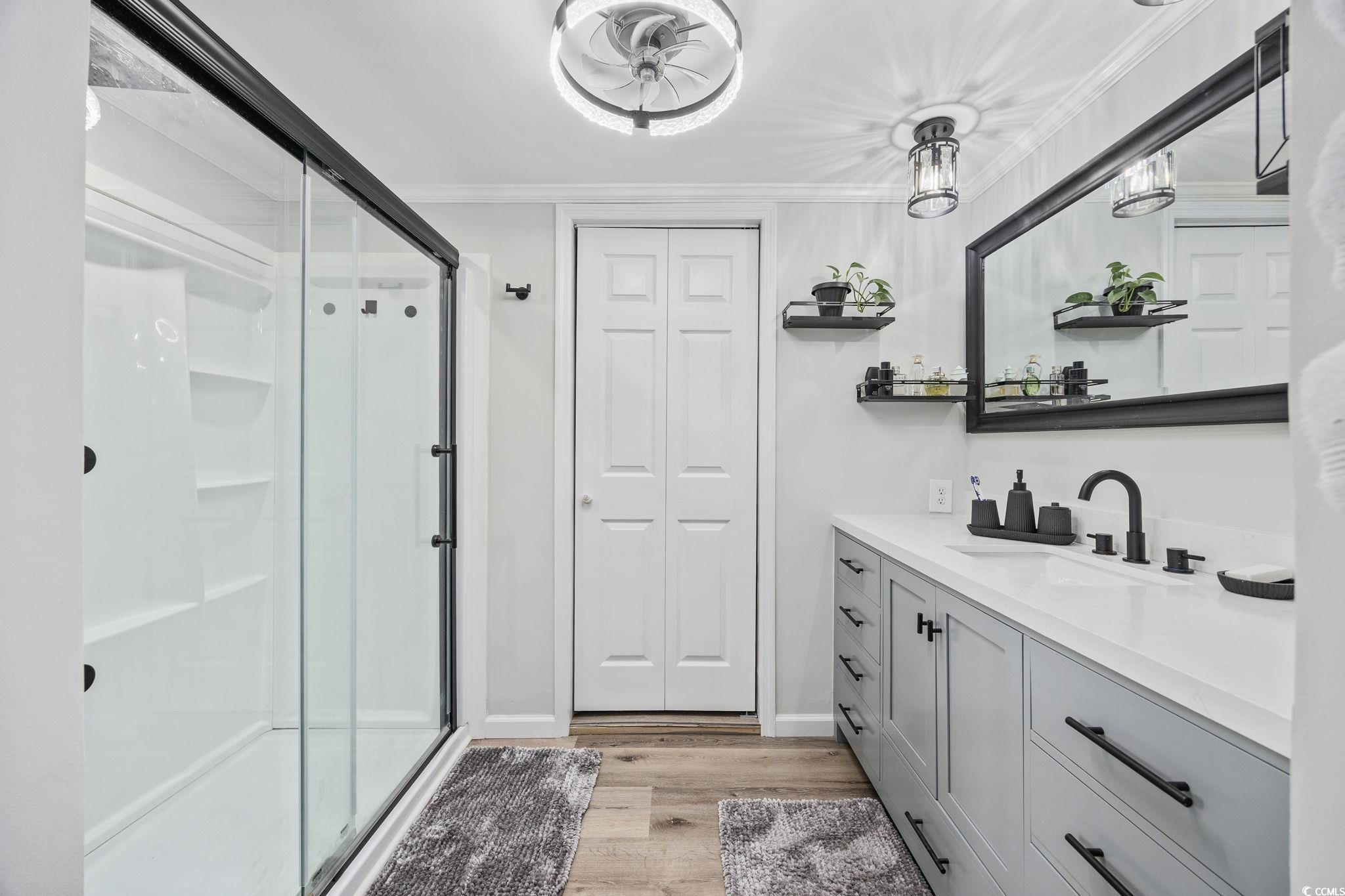 3118 State Rd S-26-816 Murrells Inlet, SC 29576 - Photo 19 of 40 Full bath with a closet, vanity, a shower stall, light wood finished floors, and crown molding