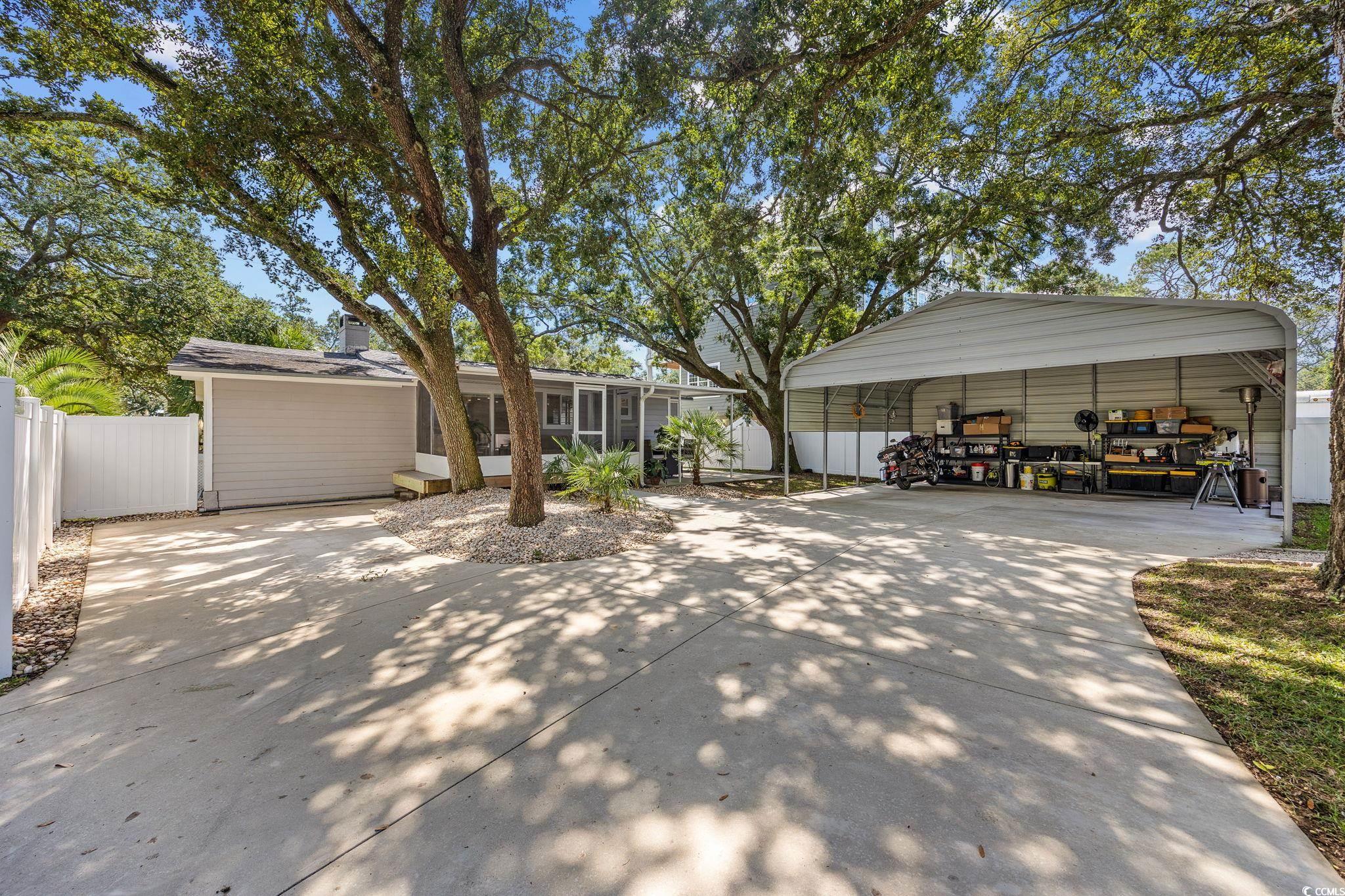 3118 State Rd S-26-816 Murrells Inlet, SC 29576 - Photo 33 of 40 Garage featuring driveway and a carport