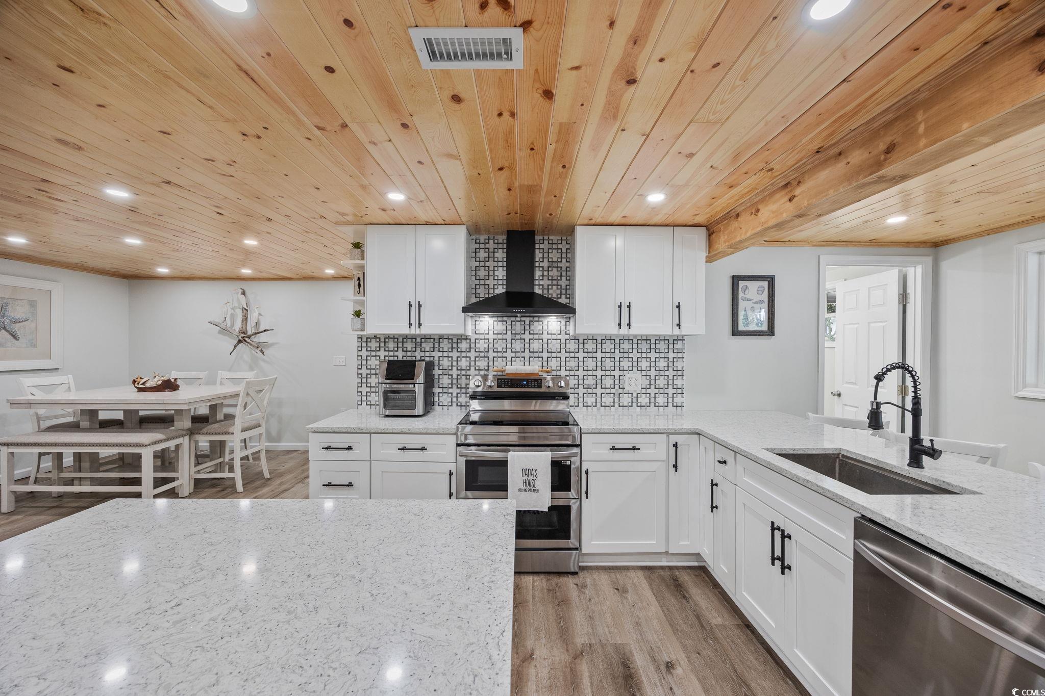 3118 State Rd S-26-816 Murrells Inlet, SC 29576 - Photo 4 of 40 Kitchen featuring white cabinets, light stone counters, decorative backsplash, light wood-style flooring, and recessed lighting