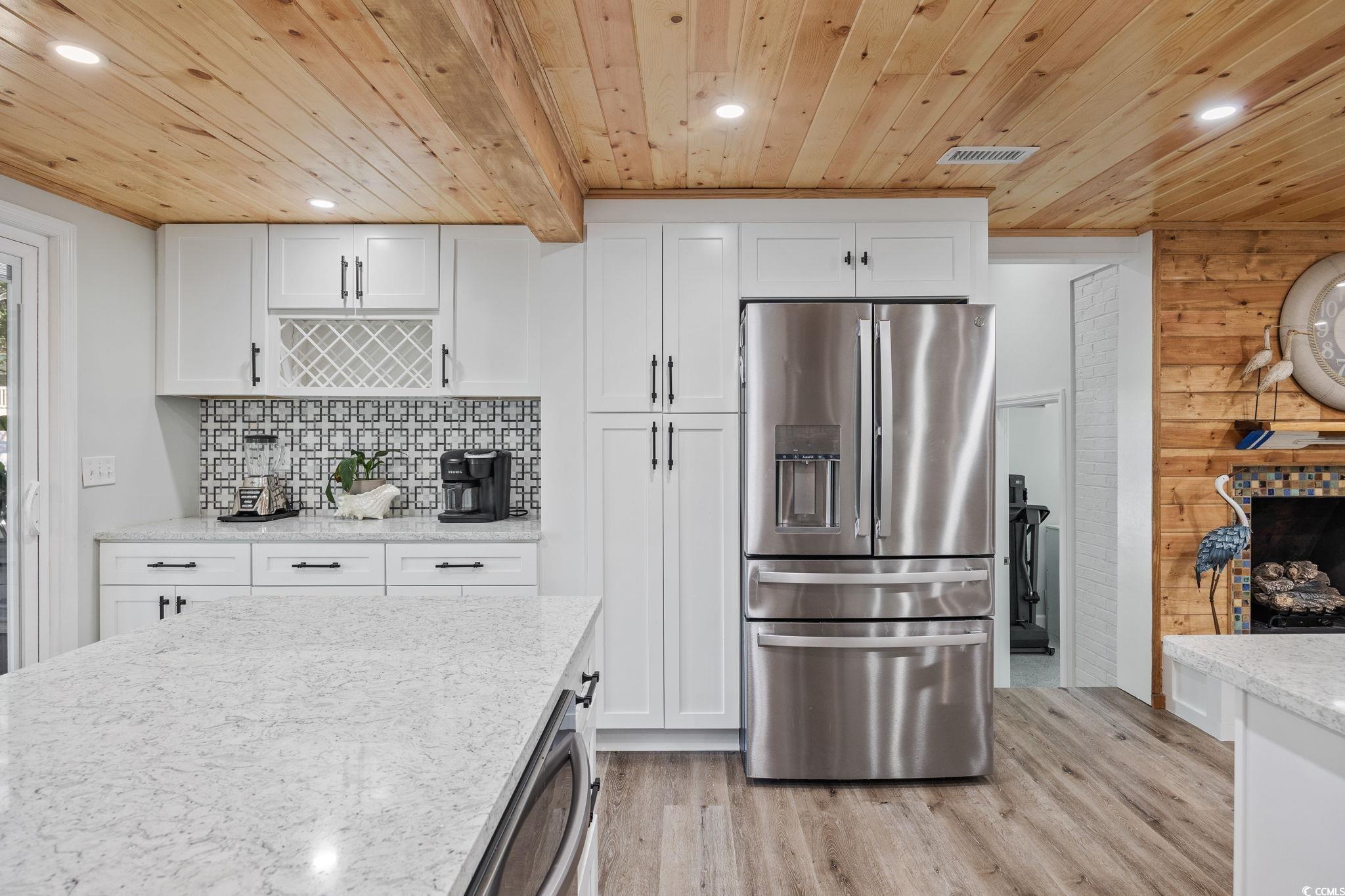 3118 State Rd S-26-816 Murrells Inlet, SC 29576 - Photo 7 of 40 Kitchen featuring stainless steel refrigerator with ice dispenser, white cabinetry, recessed lighting, light stone counters, and light wood-type flooring