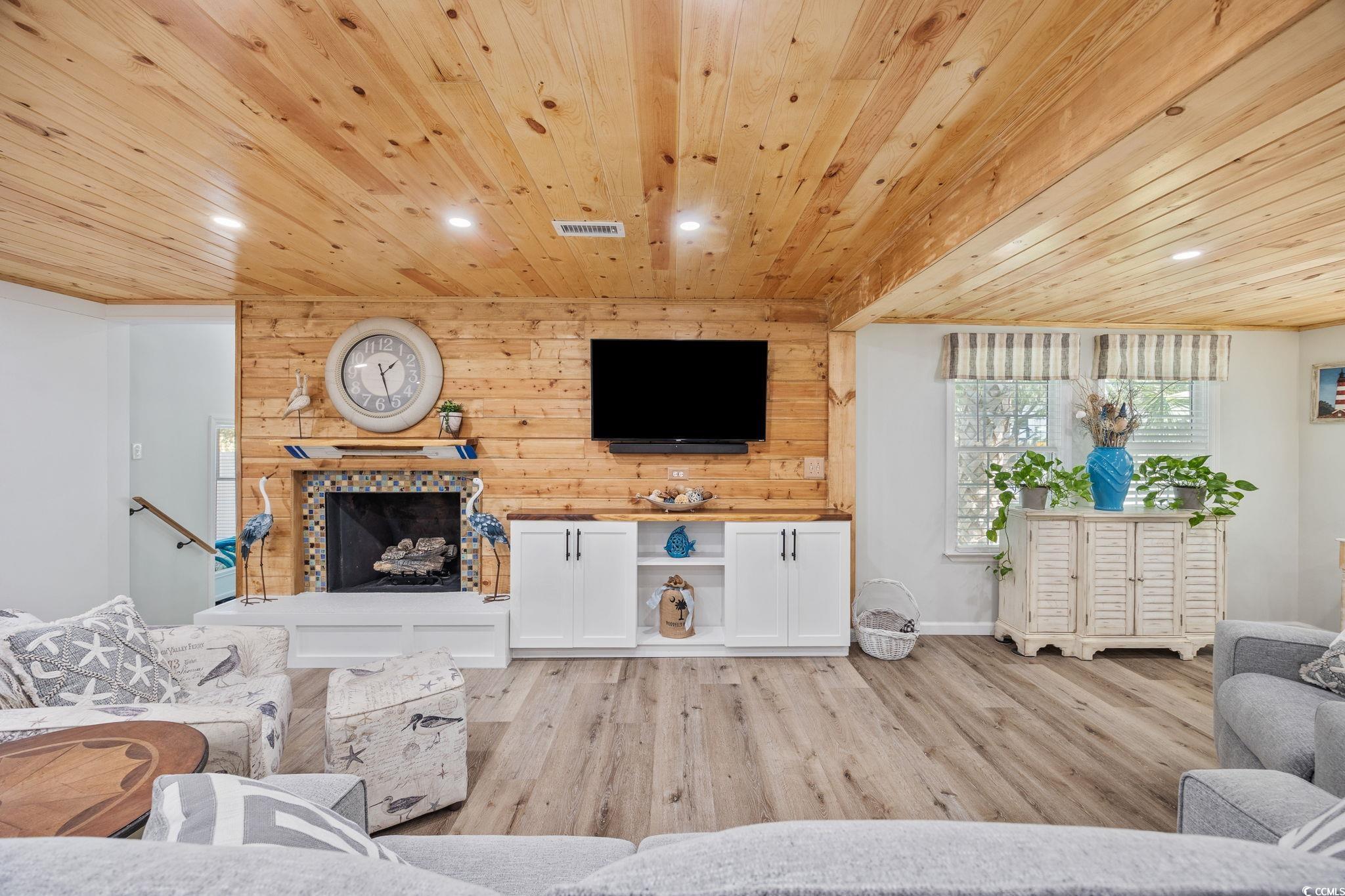 3118 State Rd S-26-816 Murrells Inlet, SC 29576 - Photo 10 of 40 Living room featuring recessed lighting, light wood-style floors, a tile fireplace, wood ceiling, and wooden walls
