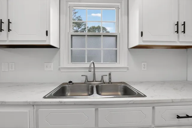 a kitchen with white cabinets and a sink