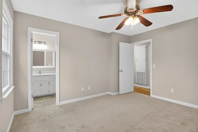 an empty room with closet and a chandelier fan
