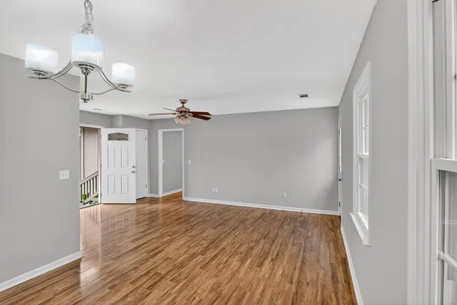 a view of empty room with wooden floor