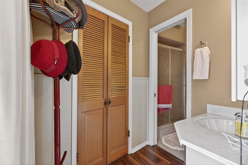 6010 Hunters View Lane Dallas, TX 75232 - Photo 23 of 28 Bathroom featuring wood-finish flooring, white wainscoting, and a neutral wall color