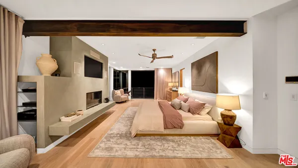 a bedroom with a large bed and a chandelier