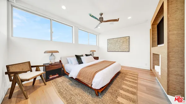 a bedroom with furniture and a large window