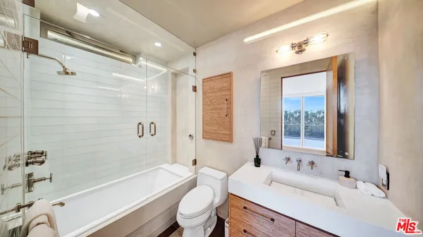 a living room with furniture entryway and a flat screen tv