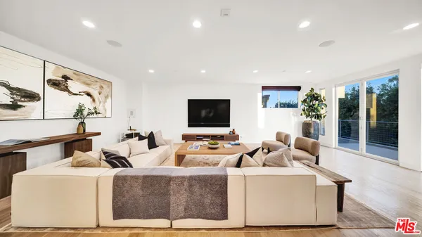 a view of roof deck with couches and wooden floor