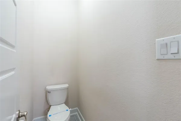 a white toilet sitting next to a white wall
