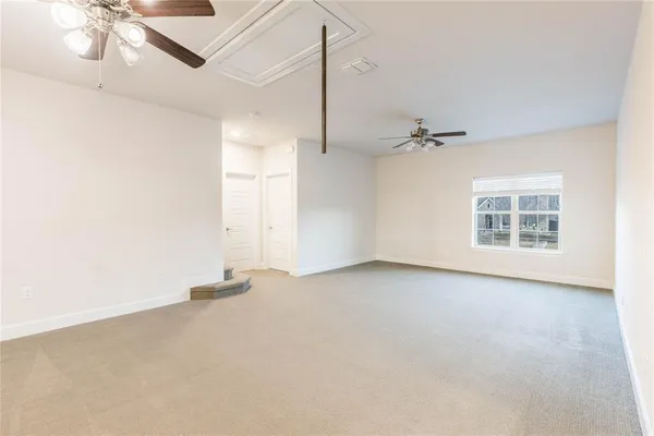 a view of a livingroom with a ceiling fan and wooden floor