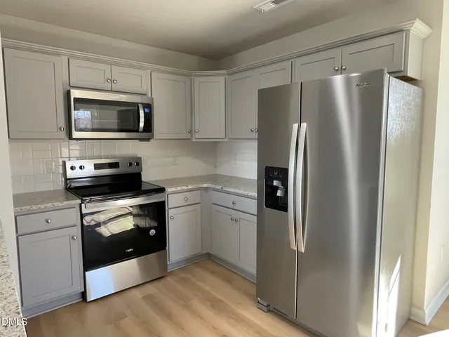 a kitchen with a refrigerator stove and microwave