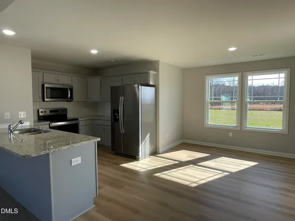 a kitchen with granite countertop a refrigerator and a stove top oven