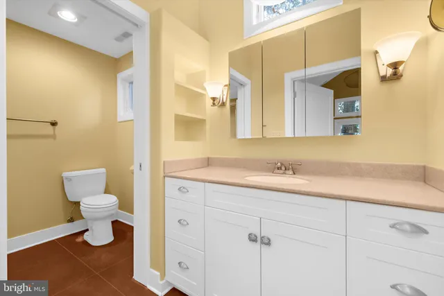 a bathroom with a toilet sink and mirror