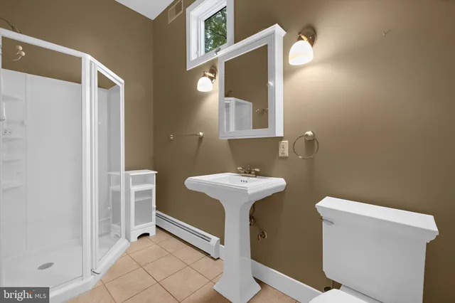 a bathroom with a sink a toilet and a mirror