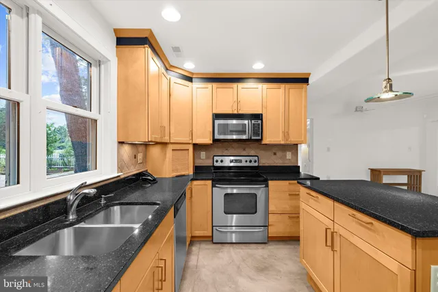 a kitchen with granite countertop a sink and a stove top oven