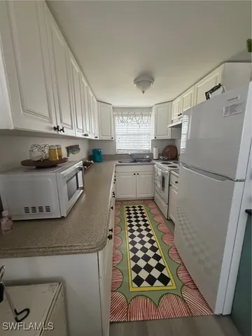 a kitchen with sink refrigerator and window