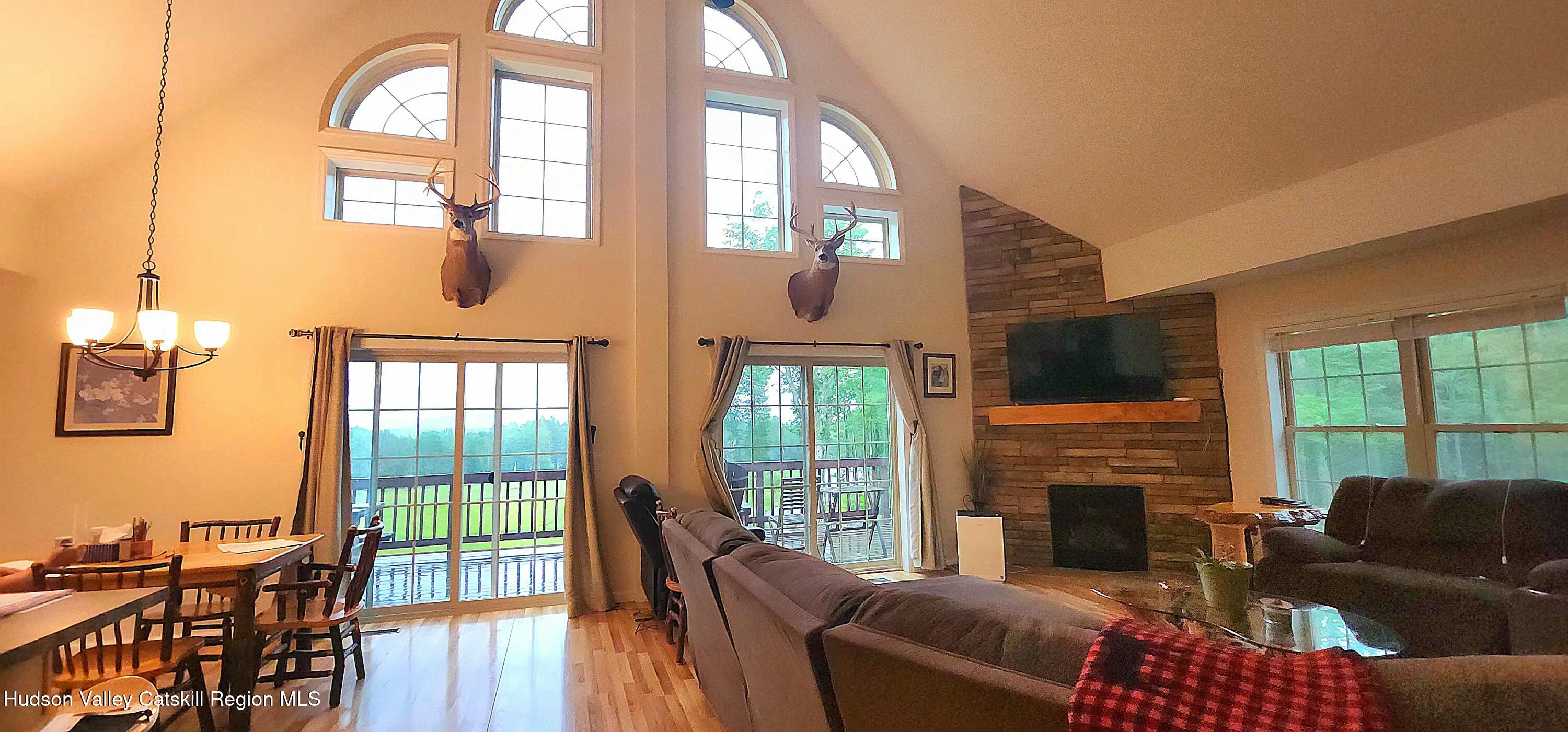 89 Zinno Road Ashland, NY 12496 - Photo 10 of 41 a living room with furniture a fireplace and floor to ceiling windows