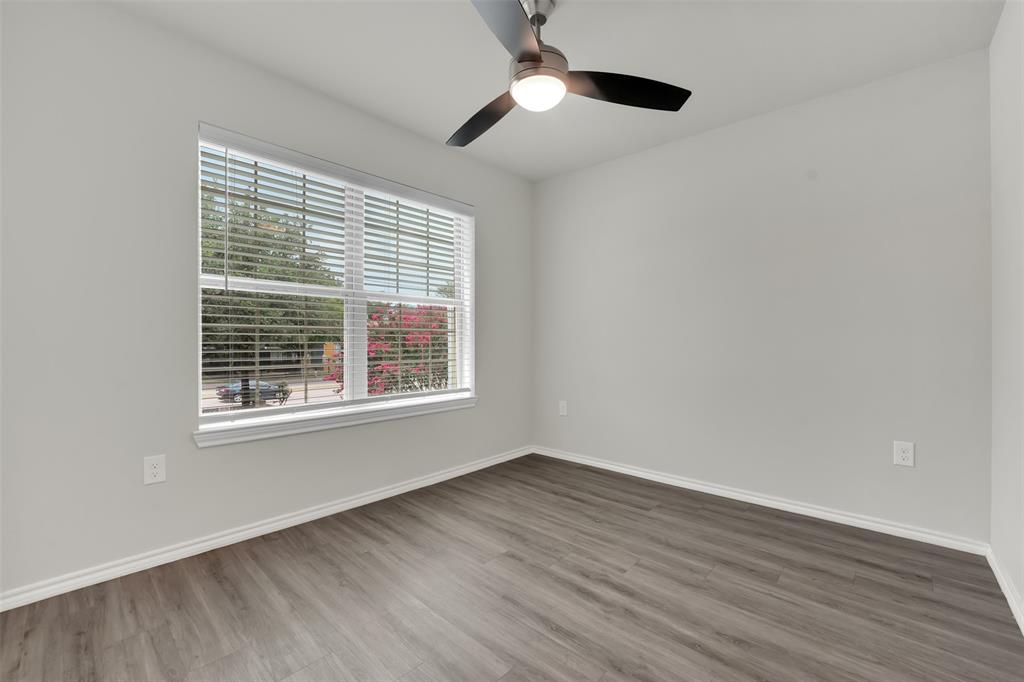 6108 Abrams Road, Unit 211 Dallas, TX 75231 - Photo 13 of 18 a view of an empty room with wooden floor and a window