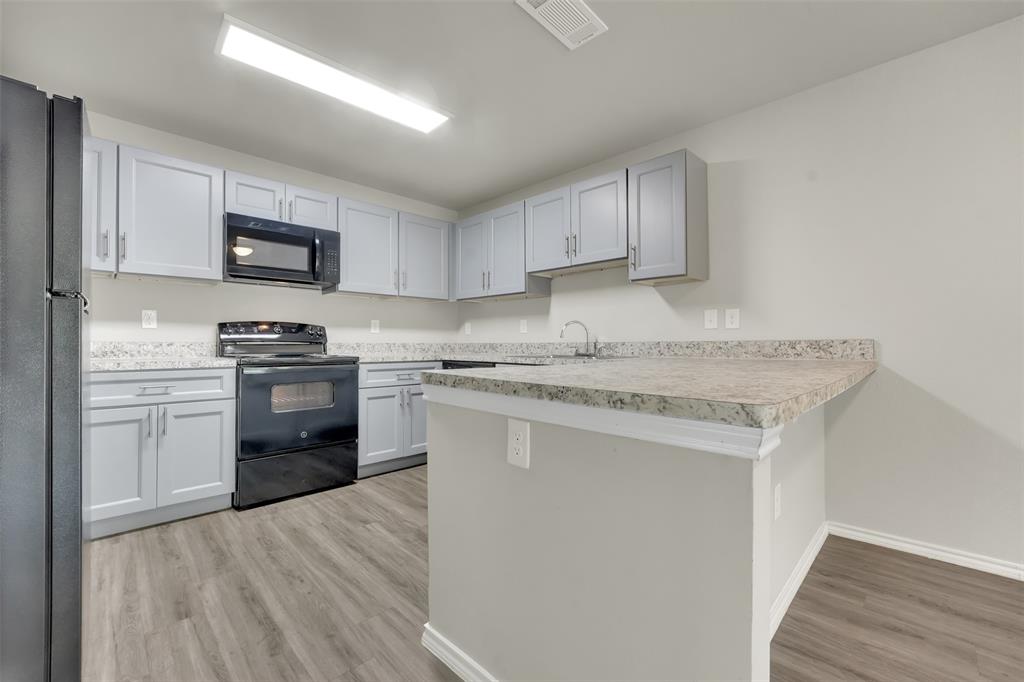 6108 Abrams Road, Unit 211 Dallas, TX 75231 - Photo 6 of 18 a kitchen with stainless steel appliances granite countertop a stove a sink and a refrigerator