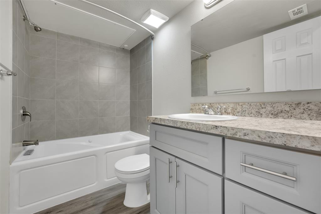 6108 Abrams Road, Unit 211 Dallas, TX 75231 - Photo 10 of 18 a bathroom with a granite countertop toilet a sink and bathtub