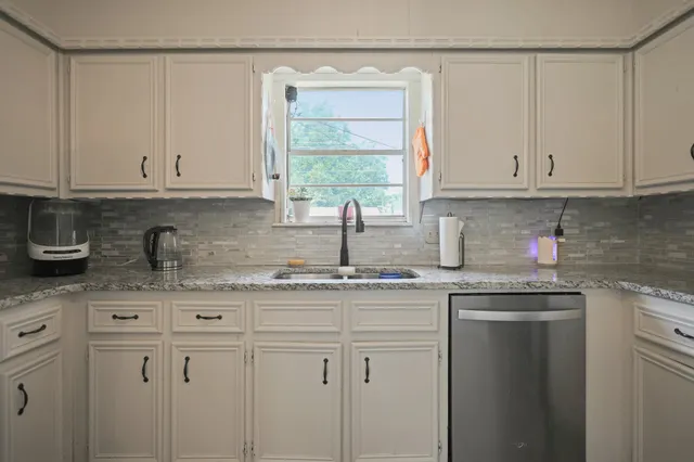 a kitchen with granite countertop white cabinets and white appliances