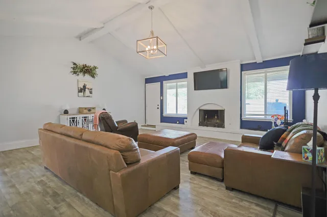 a living room with furniture a fireplace and a flat screen tv