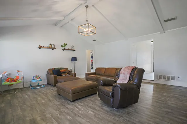 a living room with furniture flowerpot and wooden floor