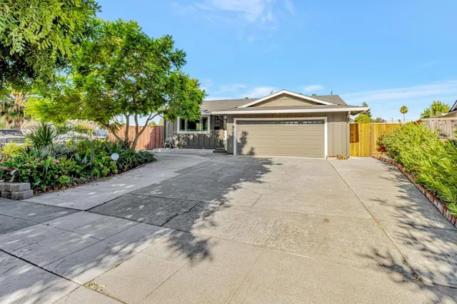 a view of a house with a yard and potted plants
