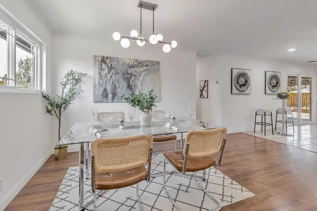 a living room with couches chairs and a potted plant