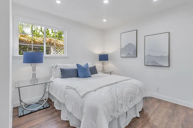 a bedroom with a bed and wooden floor