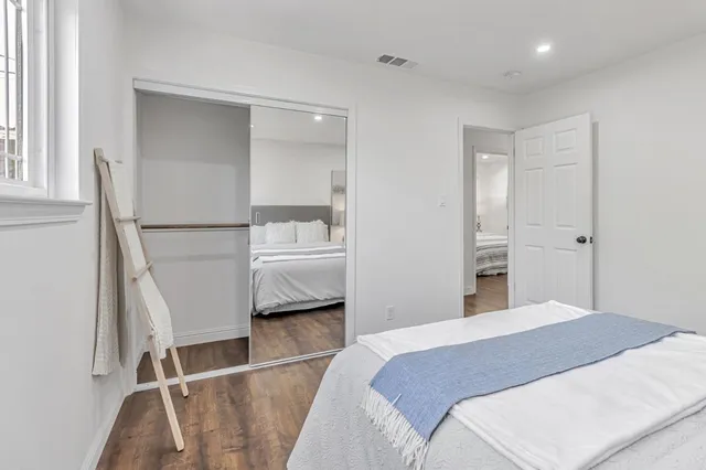 a bedroom with a bed and a refrigerator