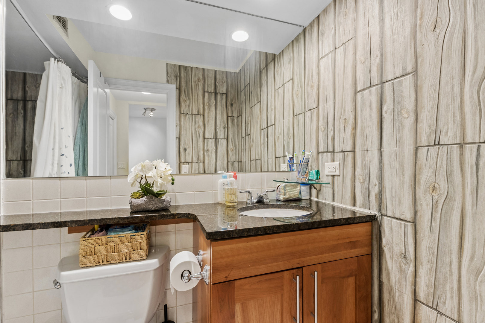 3033 North Sheridan Road, Unit 1502 Chicago, IL 60657 - Photo 10 of 19 a bathroom with a granite countertop sink and a mirror