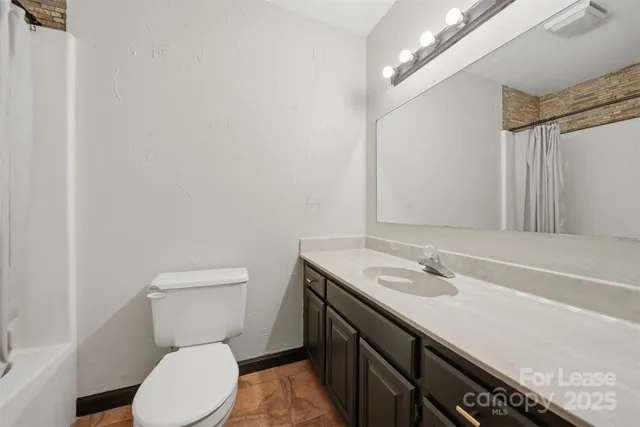 a bathroom with a sink a toilet and a mirror