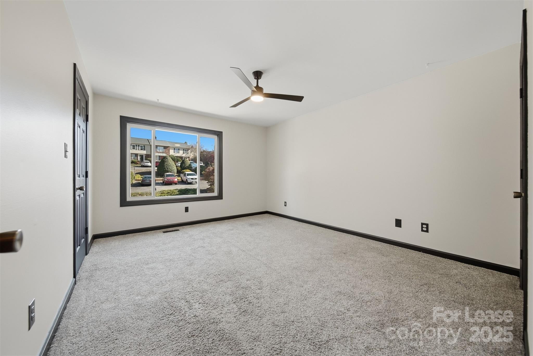 2705 North Center Street, Unit 78 Hickory, NC 28601 - Photo 12 of 17 an empty room with windows and ceiling fan