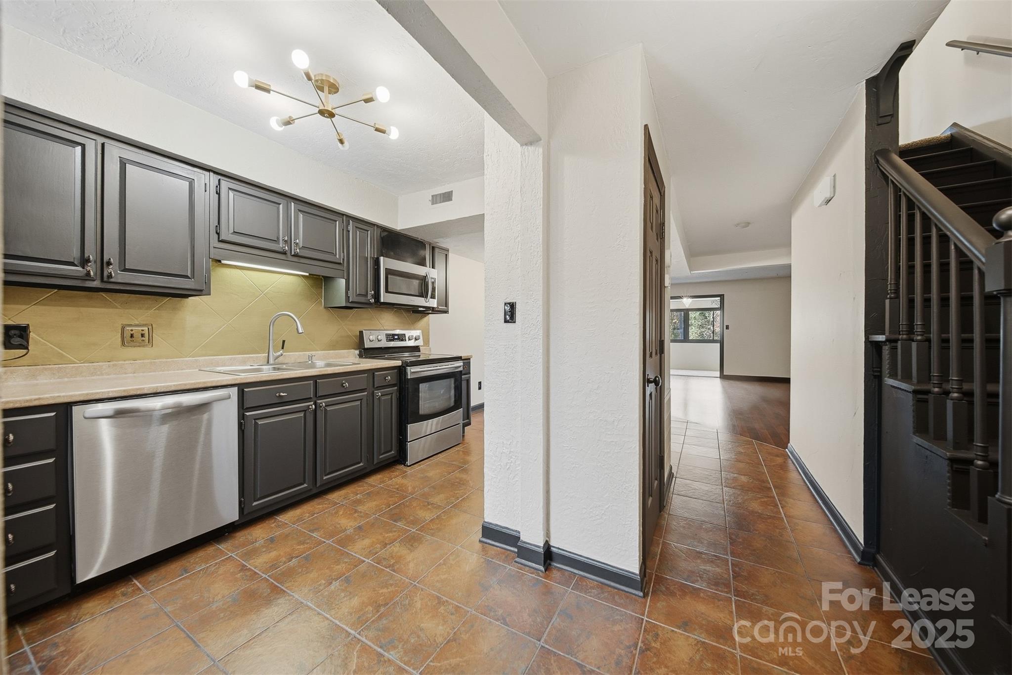 2705 North Center Street, Unit 78 Hickory, NC 28601 - Photo 6 of 17 a kitchen with granite countertop a sink cabinets and stainless steel appliances