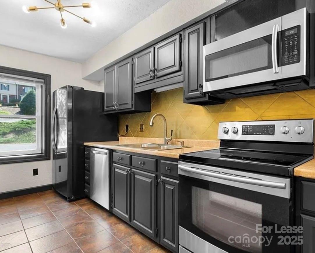 2705 North Center Street, Unit 78 Hickory, NC 28601 - Photo 8 of 17 a kitchen with stainless steel appliances granite countertop a stove microwave and cabinets