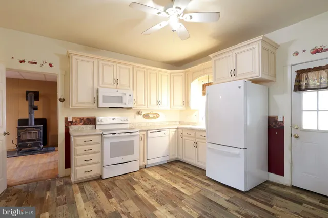 a kitchen with white cabinets and white appliances