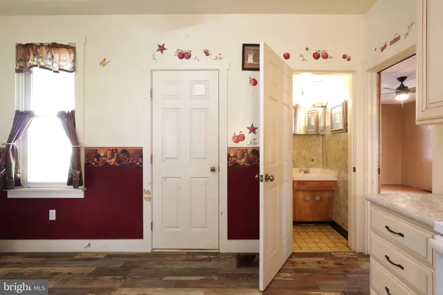 a view of a hallway with bathroom and wooden floor
