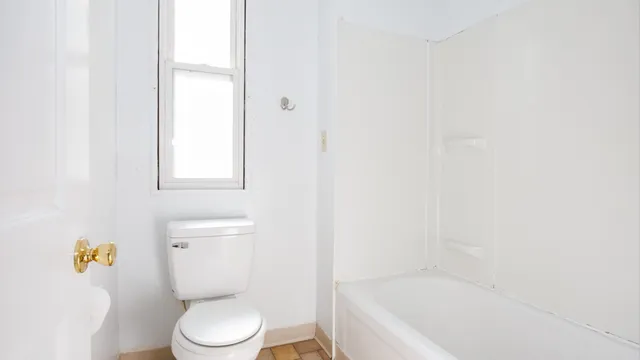 a white toilet sitting next to a bath tub