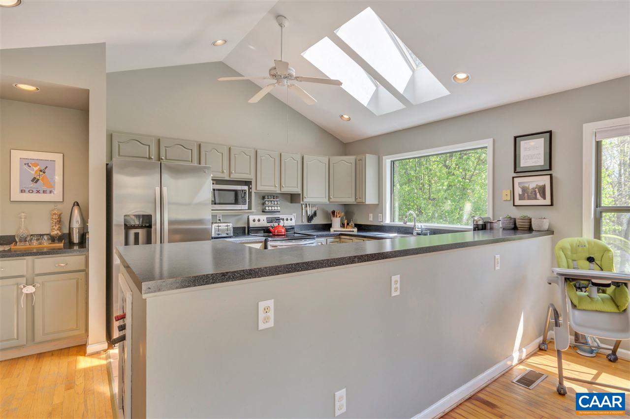 267 Turkey Ridge Road Charlottesville, VA 22903 - Photo 10 of 35 a kitchen with stainless steel appliances granite countertop a refrigerator a sink a stove a dining table and chairs with wooden floor