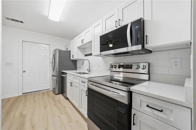 a kitchen with stainless steel appliances a stove microwave and cabinets