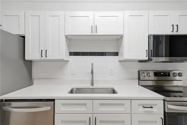 a kitchen with white cabinets and white appliances