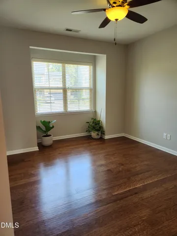 a view of a livingroom with wooden floor and a ceiling fan