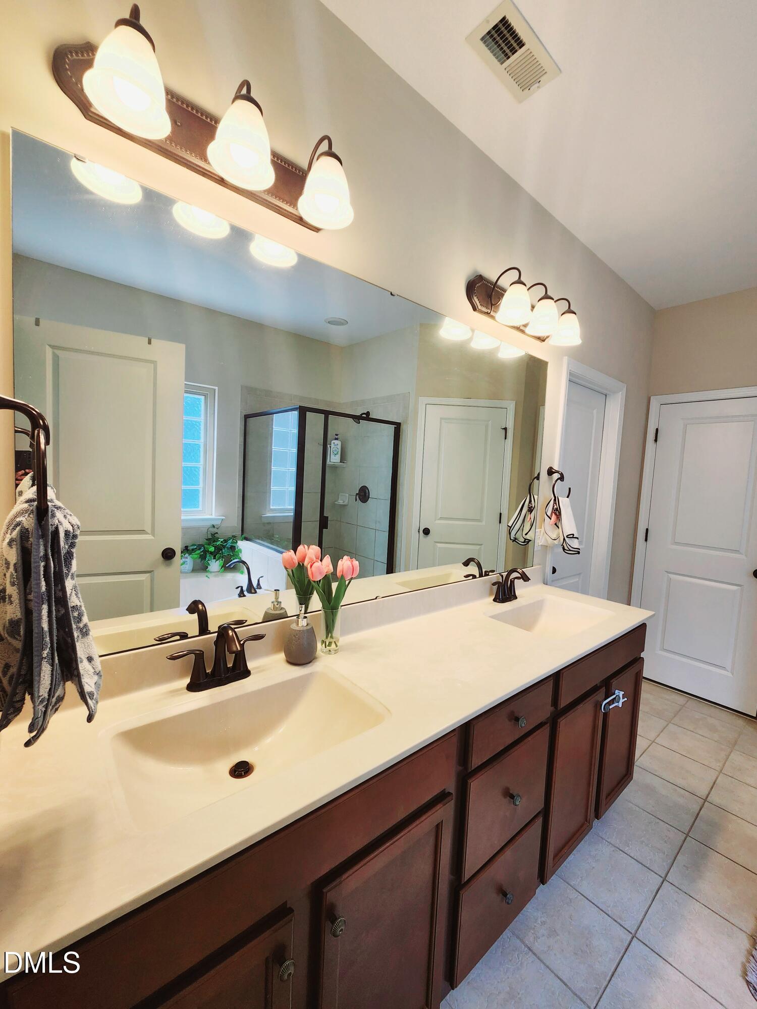 825 Wickham Ridge Road Apex, NC 27539 - Photo 18 of 31 a bathroom with a sink double vanity and a mirror