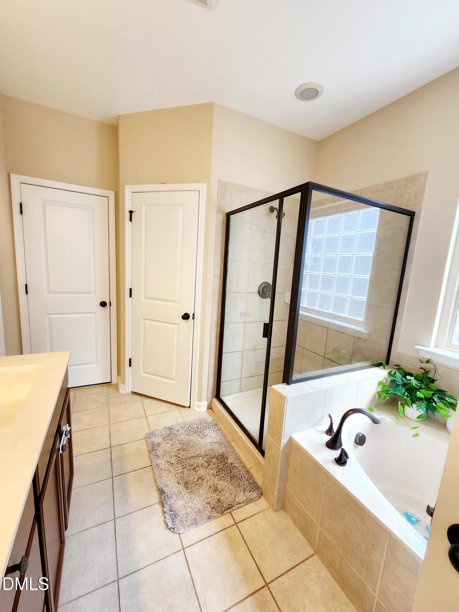825 Wickham Ridge Road Apex, NC 27539 - Photo 19 of 31 a bathroom with a tub shower and a sink