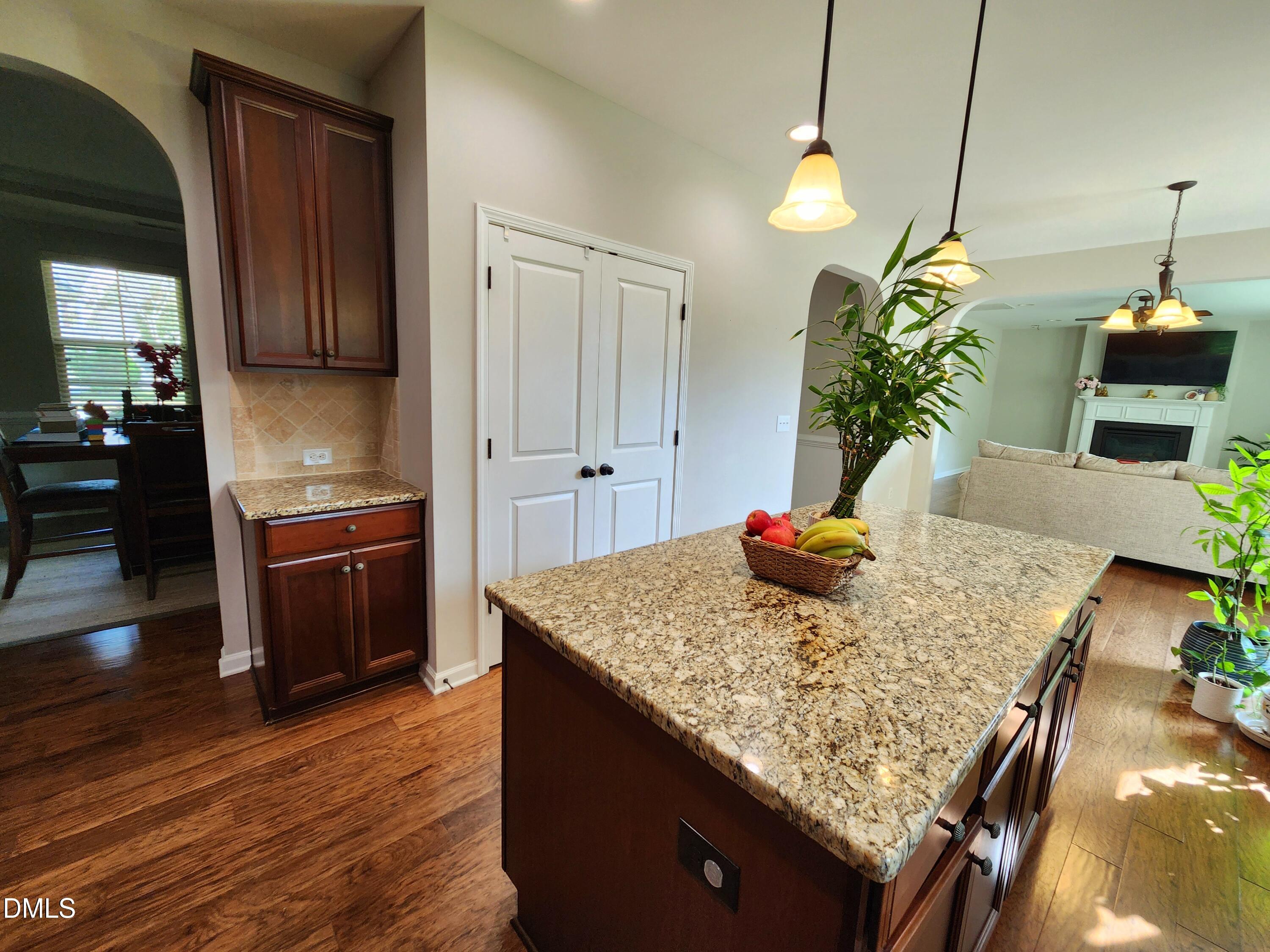 825 Wickham Ridge Road Apex, NC 27539 - Photo 9 of 31 a kitchen with kitchen island granite countertop wooden cabinets and a granite counter tops