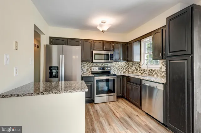 a kitchen with stainless steel appliances granite countertop a refrigerator stove and oven