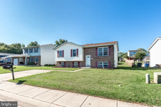 a front view of a house with a yard and trees